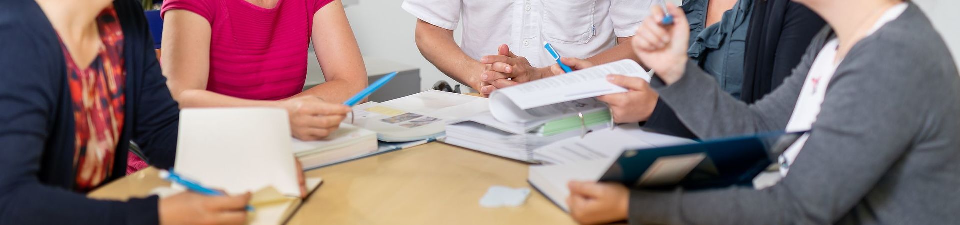 Group of people sitting around a table with documents for a meeting