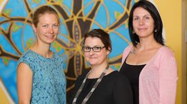 3 women in front of a painting