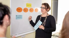 Person standing in front of a whiteboard explaining something to auditors