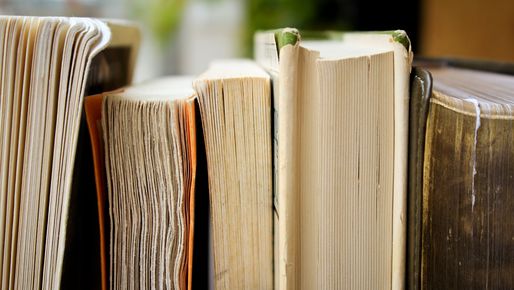 Five huge books with many pages standing beneath each other