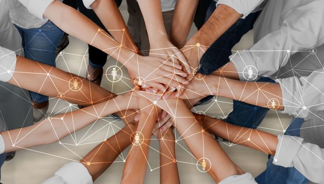 People in Circle holding their Hands Together in the middle, view from the top